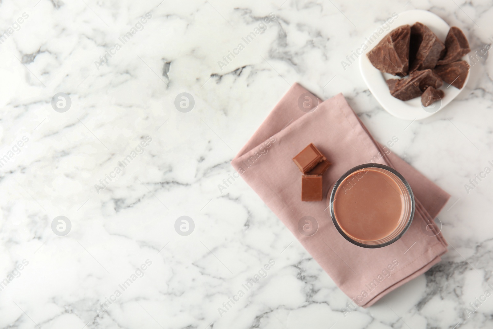 Photo of Flat lay composition with glass of tasty chocolate milk and space for text on marble background. Dairy drink