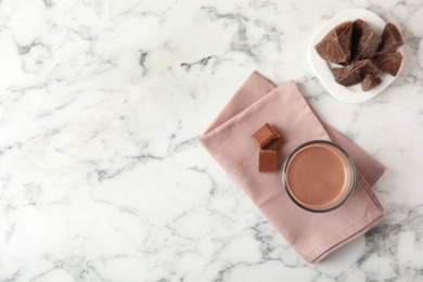 Flat lay composition with glass of tasty chocolate milk and space for text on marble background. Dairy drink