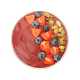 Photo of Bowl of delicious smoothie with fresh blueberries, strawberries and pumpkin seeds on white background, top view