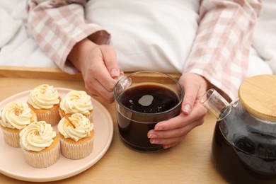 Photo of Woman with cup of hot drink in bed, closeup