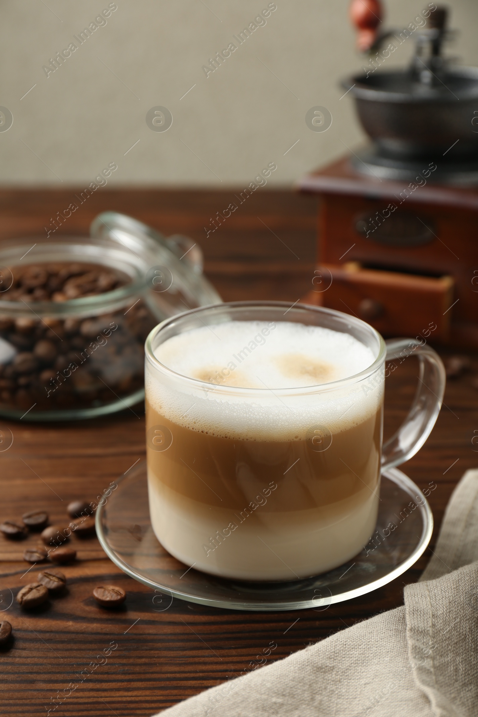 Photo of Aromatic coffee in cup and beans on wooden table