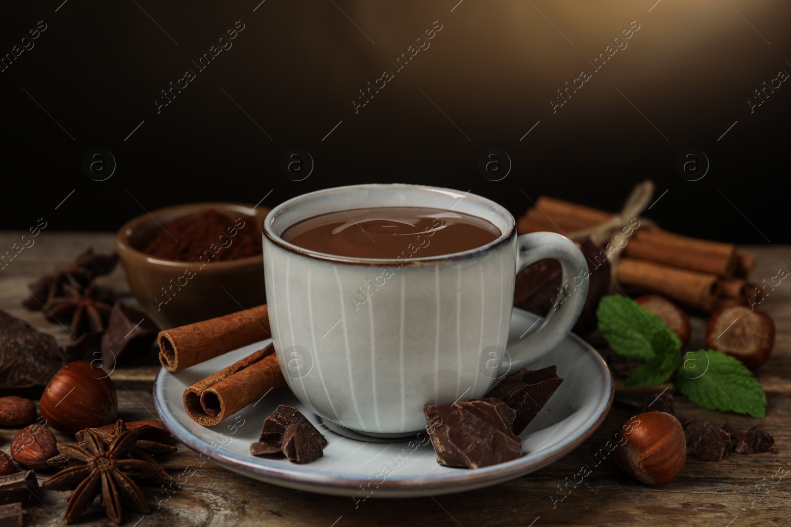 Photo of Composition with yummy hot chocolate in cup on wooden table