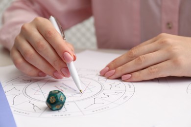 Astrologer using zodiac wheel for fate forecast at table, closeup. Fortune telling