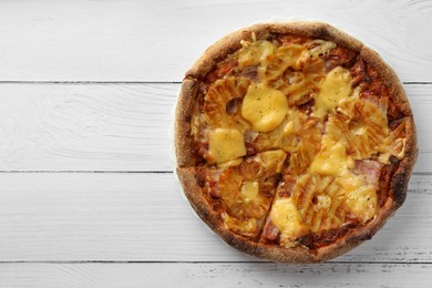 Photo of Delicious Hawaiian pizza with pineapple on white wooden table, top view. Space for text
