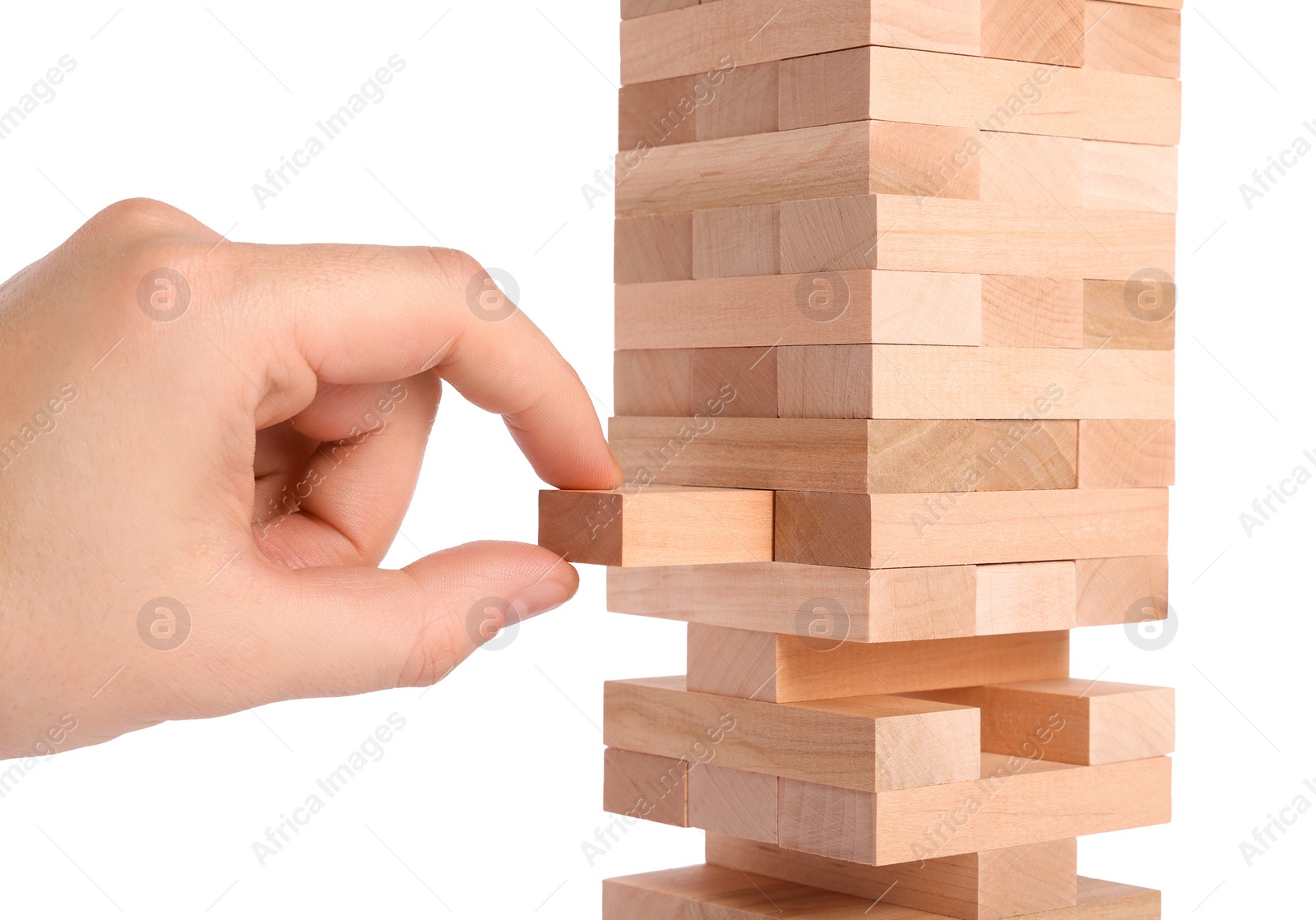 Photo of Playing Jenga. Man removing wooden block from tower on white background, closeup