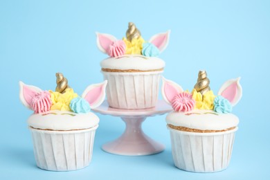 Cute sweet unicorn cupcakes on light blue background