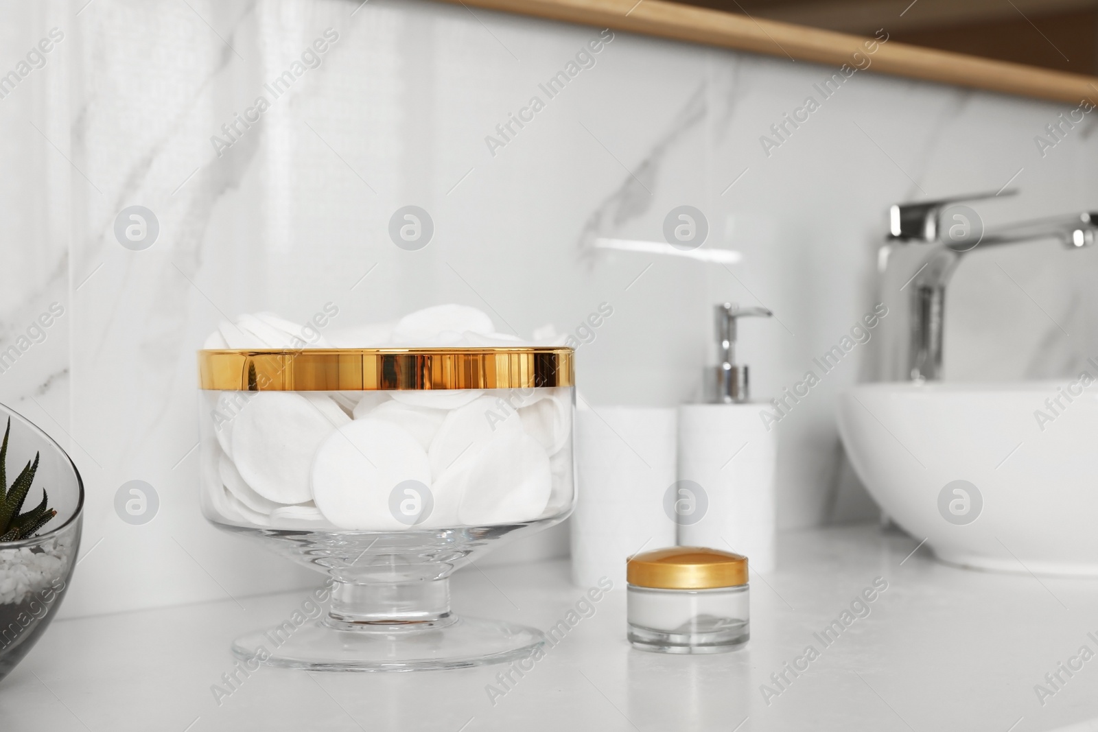 Photo of Jar with cotton pads on bathroom countertop