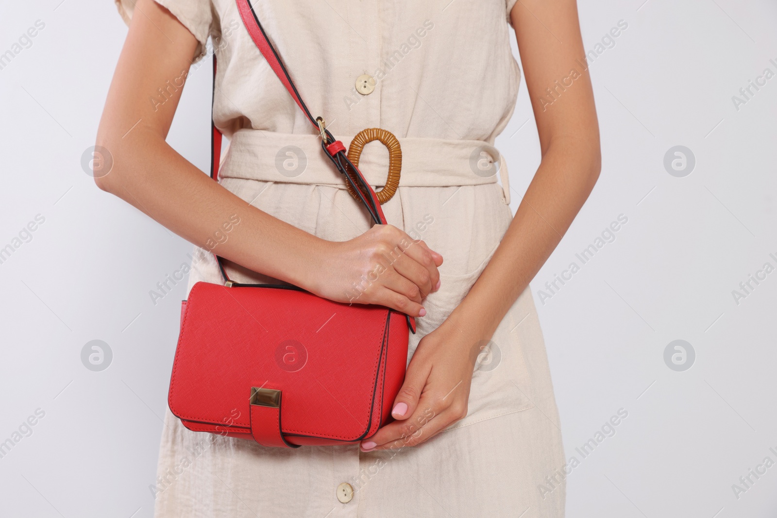 Photo of Woman with stylish red bag on light grey background, closeup