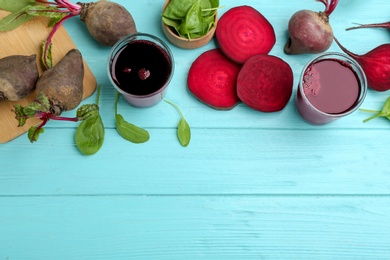 Photo of Fresh beet juice and raw vegetable on blue wooden table, flat lay. Space for text