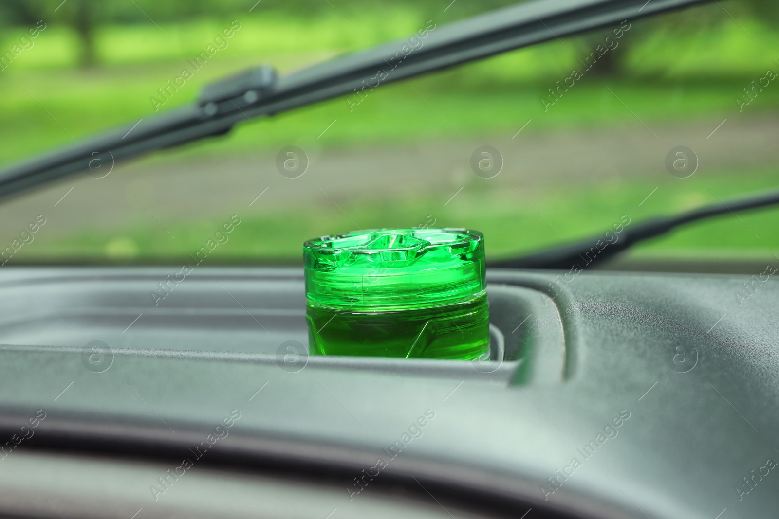 Photo of Stylish air freshener on dashboard in car