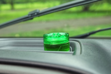 Stylish air freshener on dashboard in car