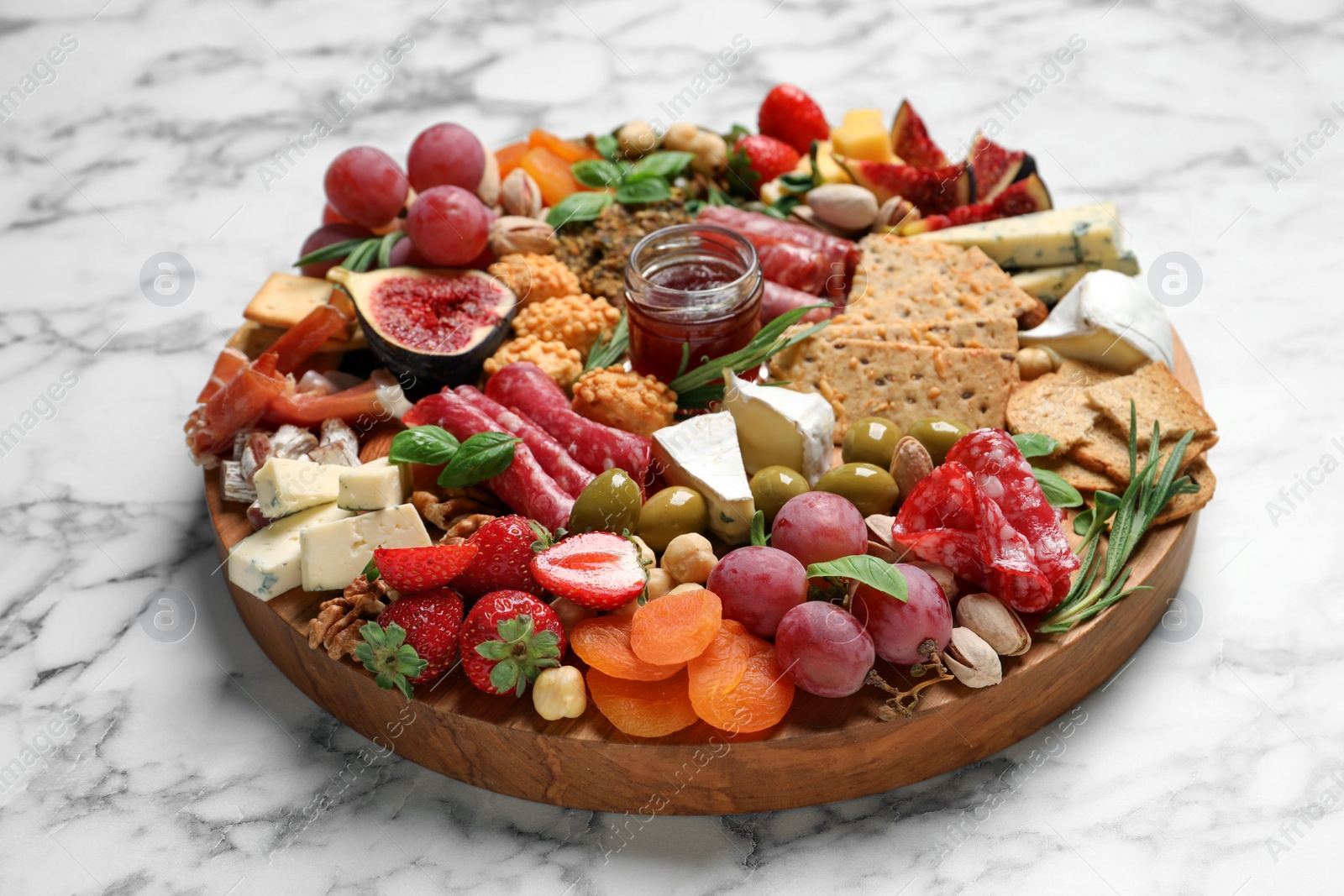 Photo of Different tasty appetizers on white marble table