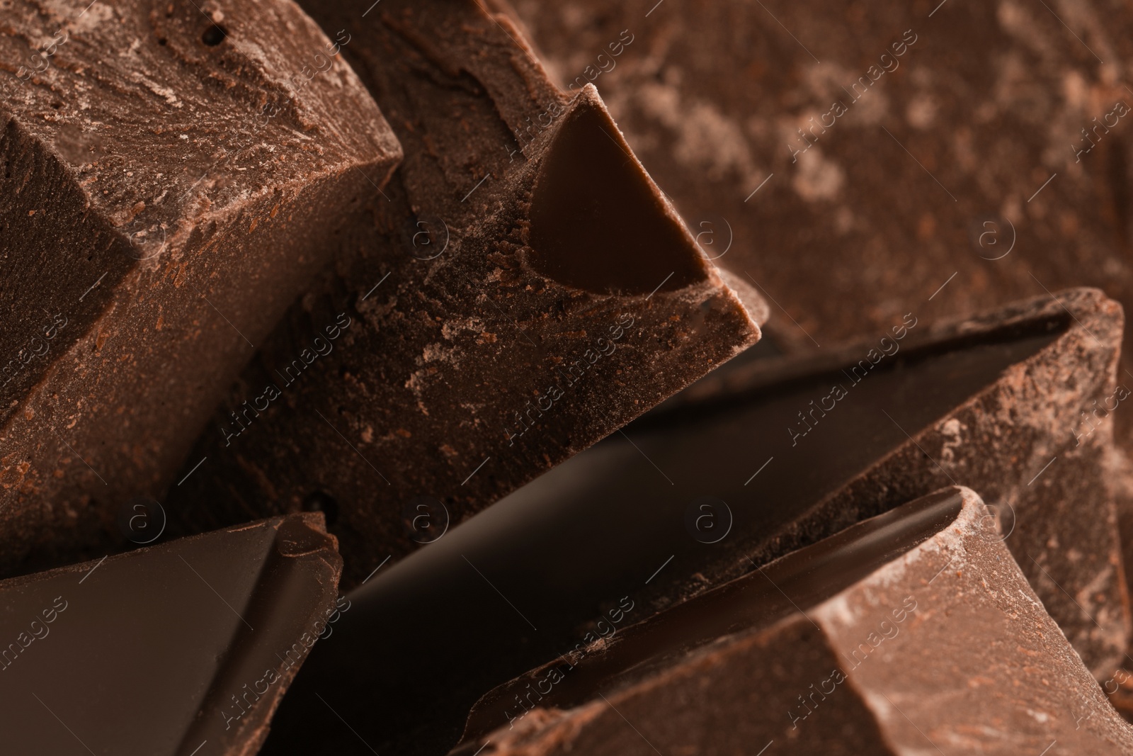 Photo of Pieces of dark chocolate as background, closeup