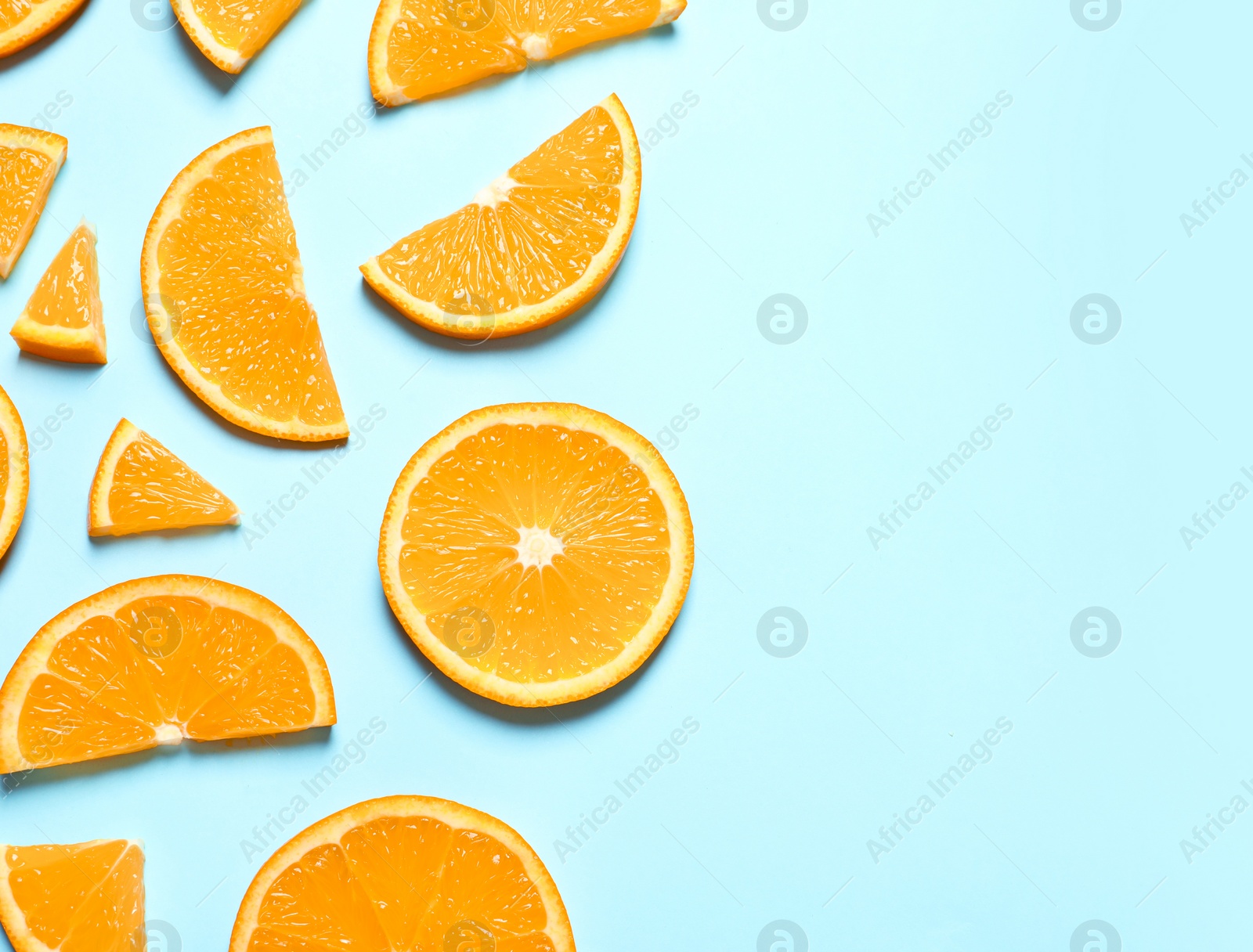 Photo of Flat lay composition with orange slices and space for text on color background