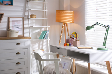 Photo of Stylish room interior with comfortable workplace near window