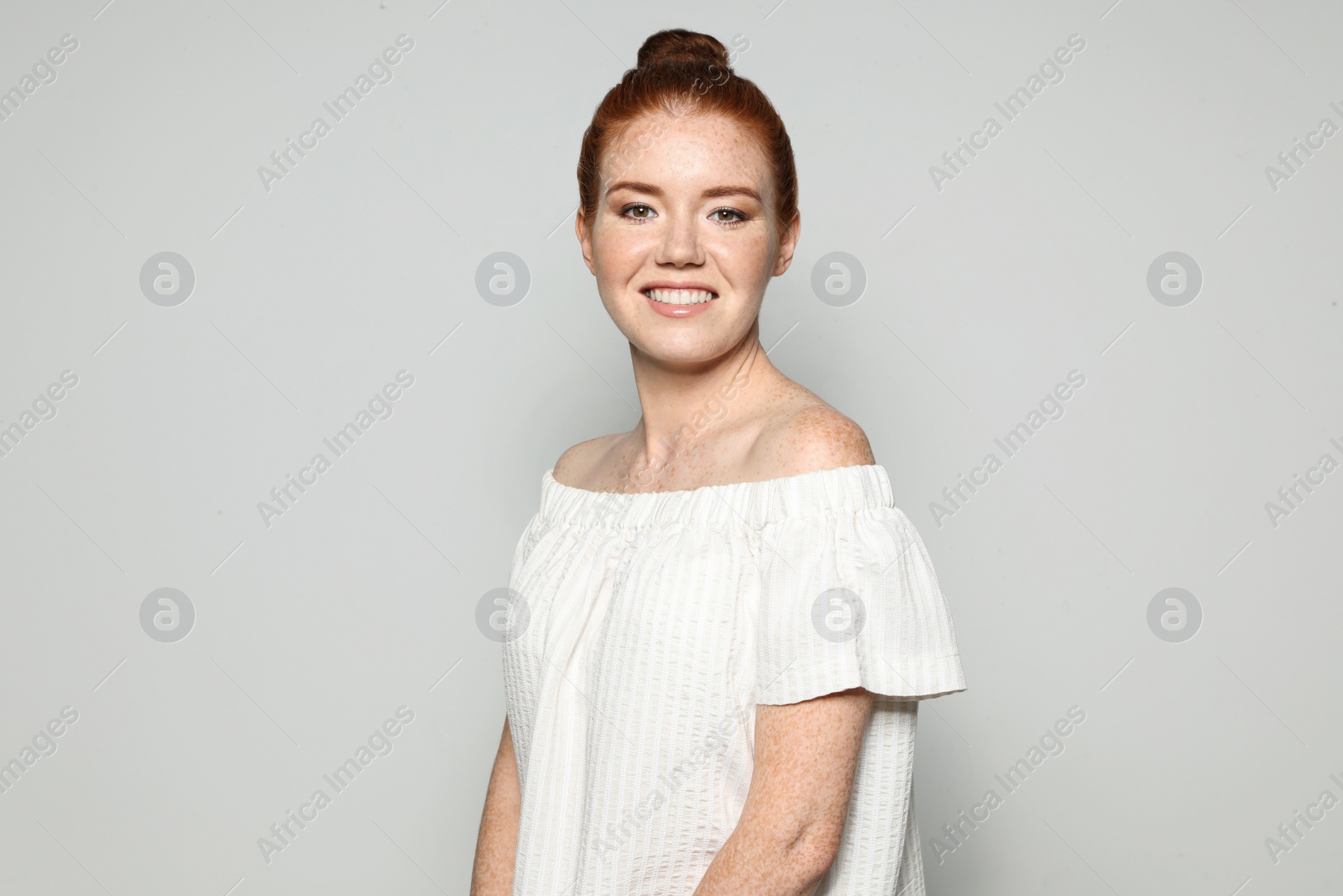 Photo of Portrait of young woman with beautiful face on grey background