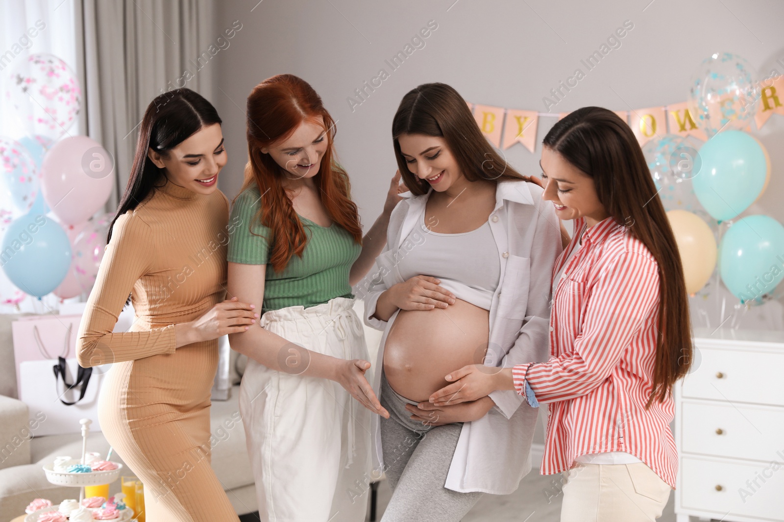 Photo of Happy pregnant woman spending time with friends at baby shower party