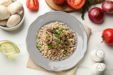 Photo of Delicious pearl barley with onion and mushrooms served on white marble table, flat lay