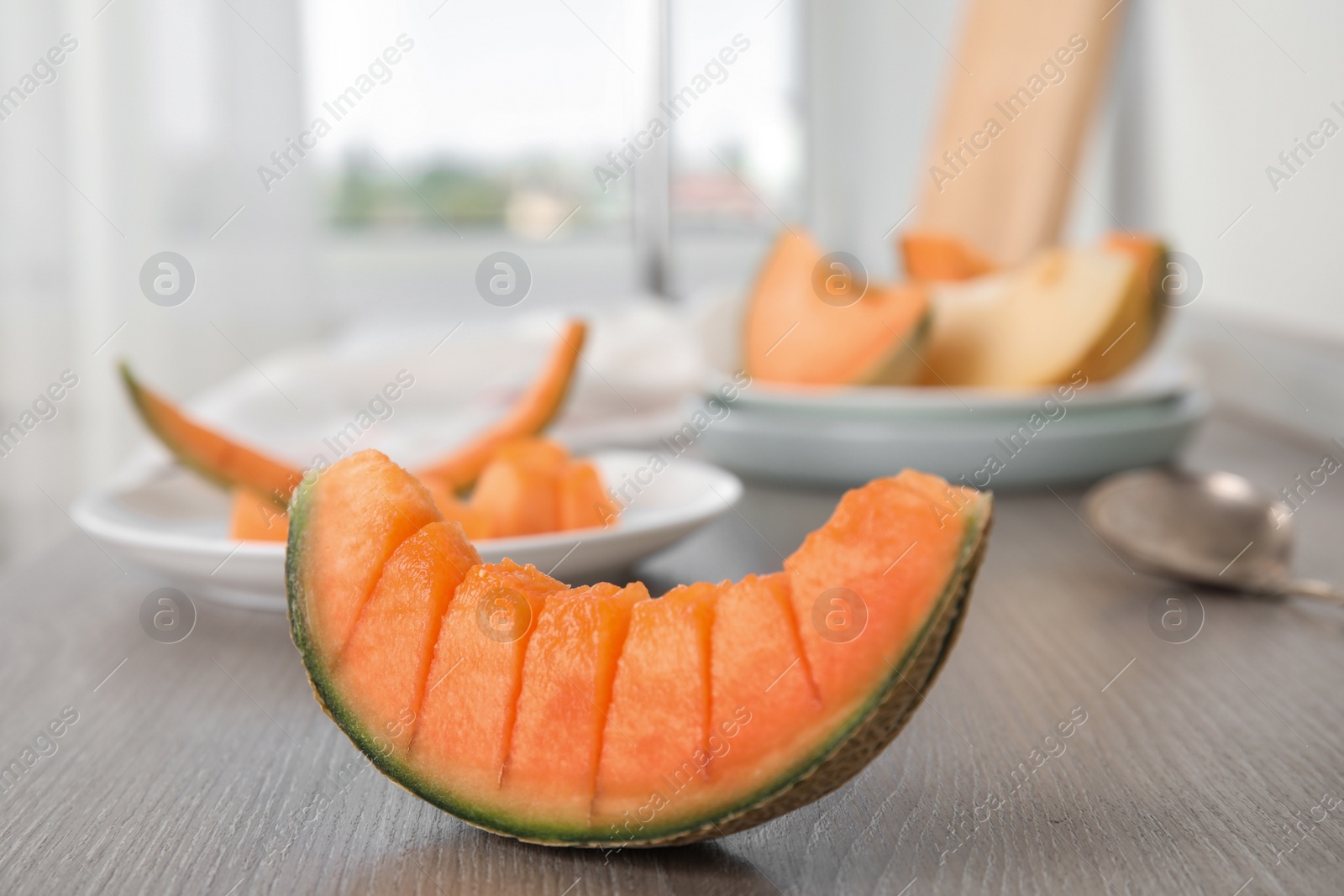 Photo of Slice of ripe cantaloupe melon on wooden table