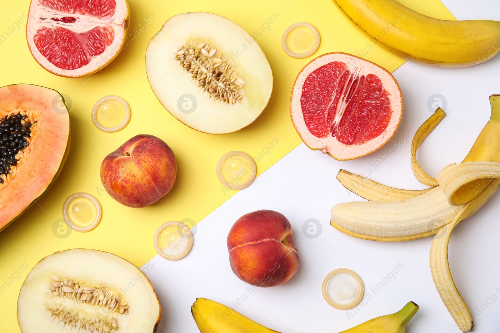 Photo of Flat lay composition with condoms and exotic fruits on color background. Erotic concept