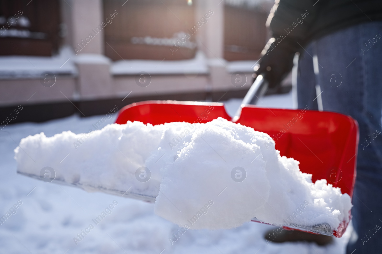 Photo of Person shoveling snow outdoors on winter day, closeup