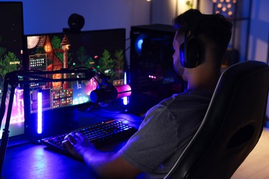 Photo of Man playing video games on computer at table indoors