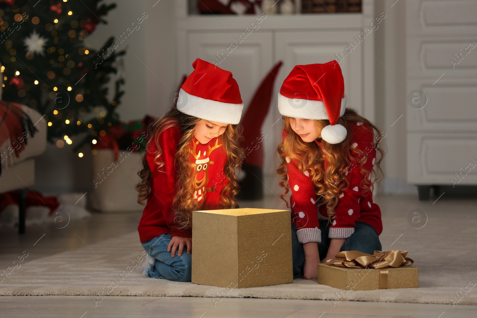 Photo of Cute little girls with Christmas gift at home. Magic atmosphere