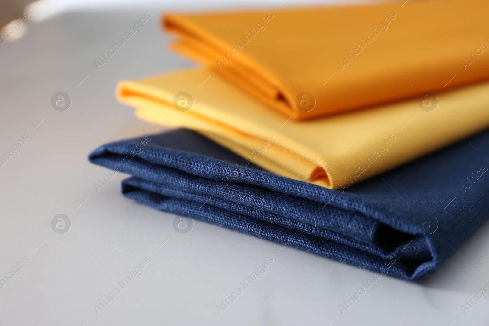 Photo of Different colorful napkins on white table, closeup