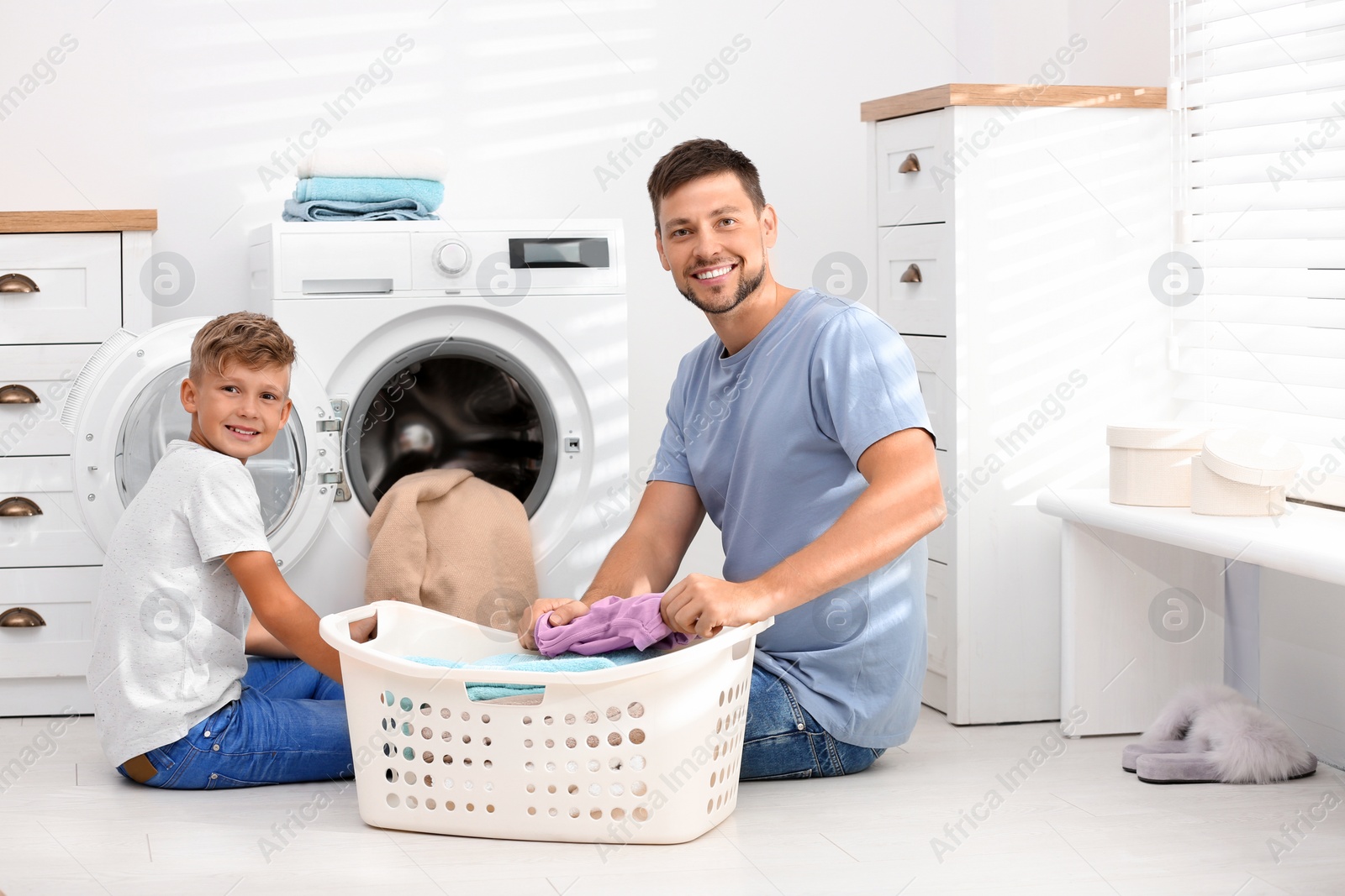 Photo of Dad and son doing laundry at home