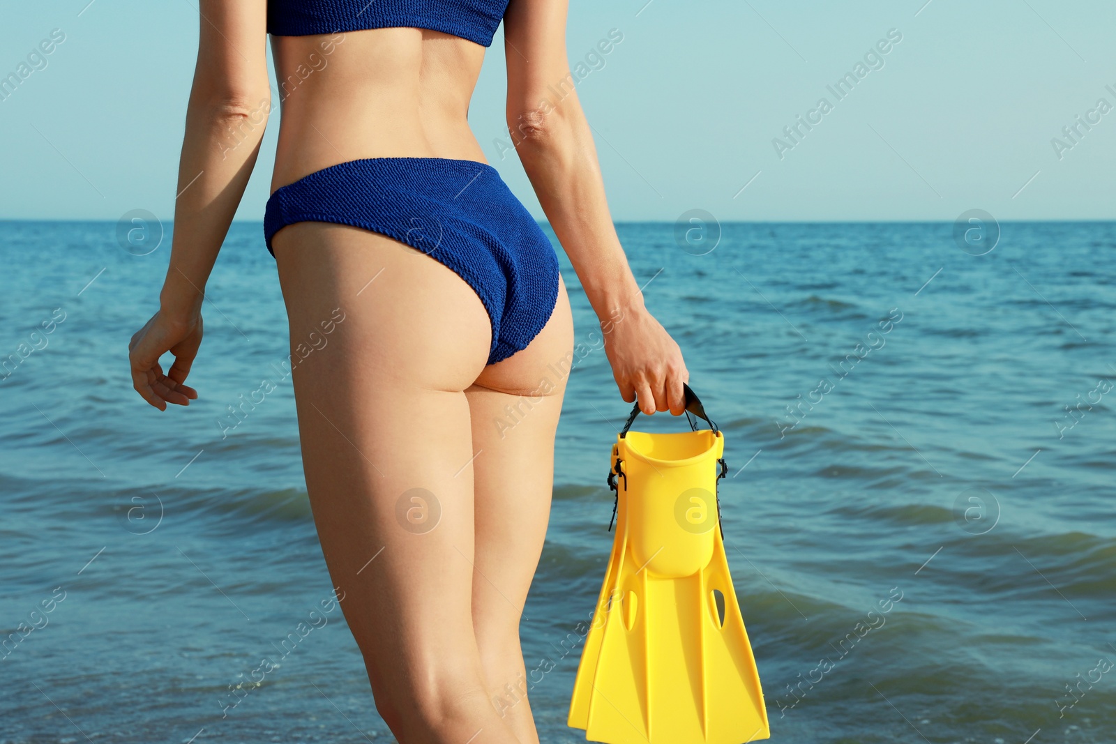 Photo of Woman with flippers walking on beach, closeup