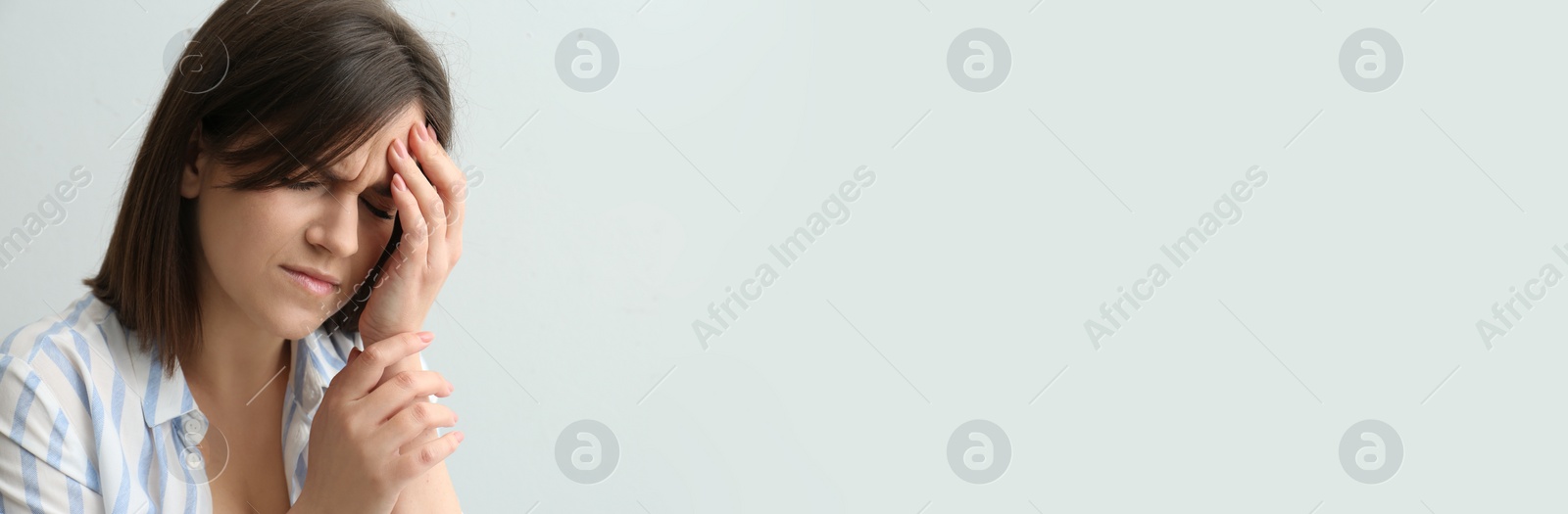 Image of Young woman suffering from migraine on white background, space for text. Banner design