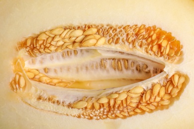 Photo of Tasty cut ripe melon with seeds as background, closeup