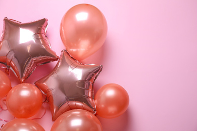 Colorful balloons on pink background, flat lay. Space for text