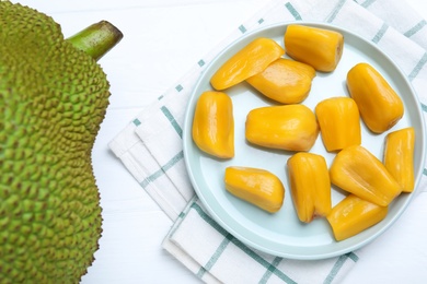 Photo of Delicious exotic jackfruit and bulbs on white table, flat lay