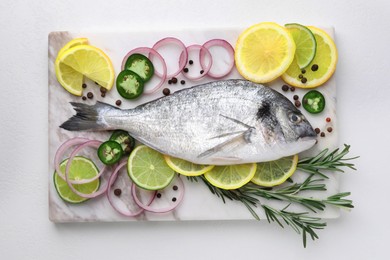Photo of Fresh dorado fish and spices on white table, top view