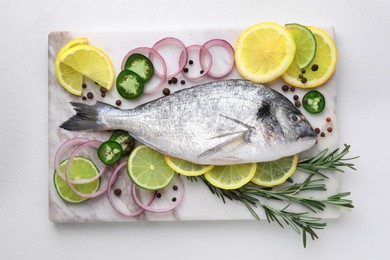 Fresh dorado fish and spices on white table, top view