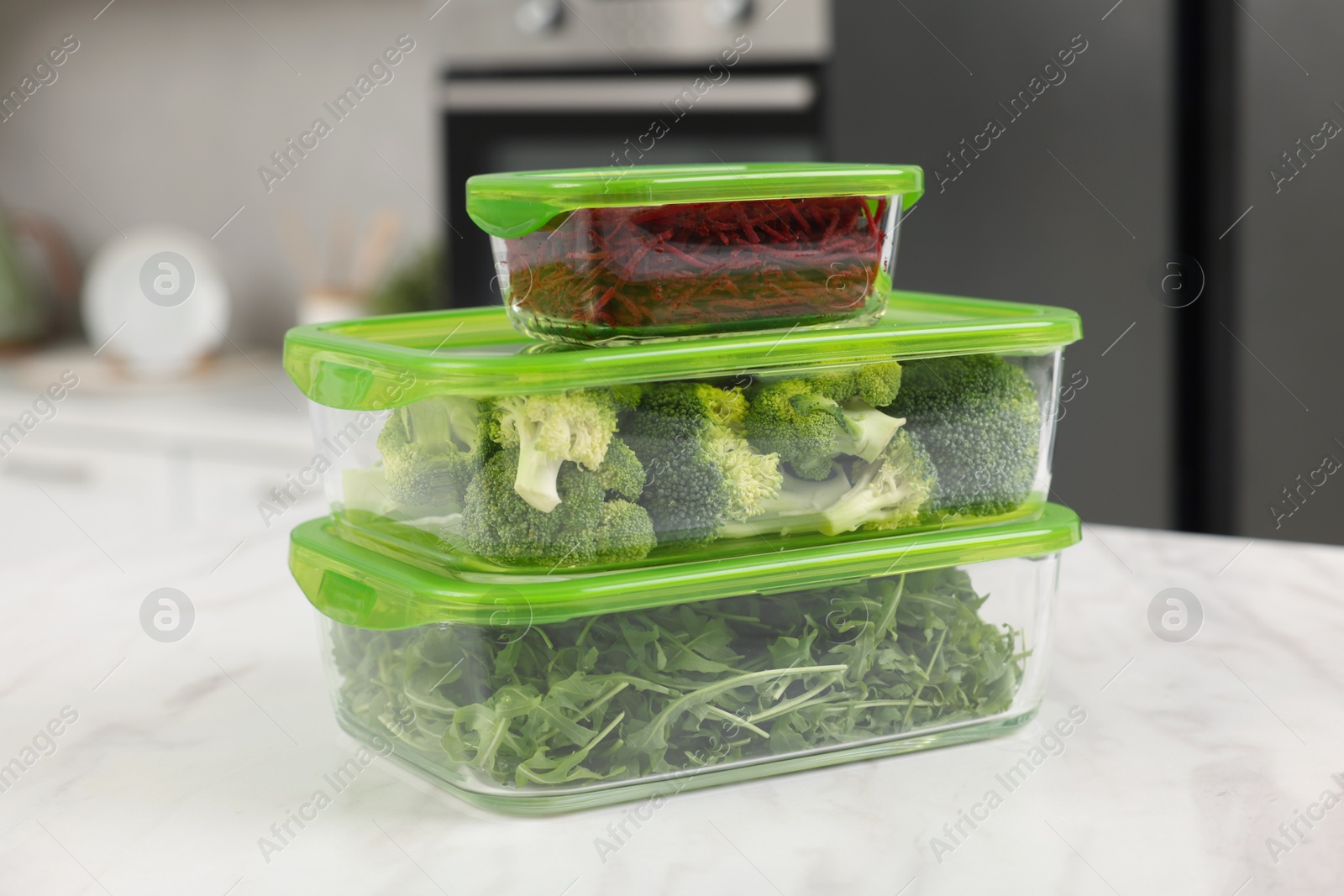 Photo of Glass containers with different fresh products on white marble table in kitchen, closeup. Food storage