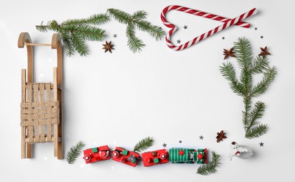 Photo of Christmas greeting card with space for text. Flat lay composition of fir tree branches and festive decor on white background