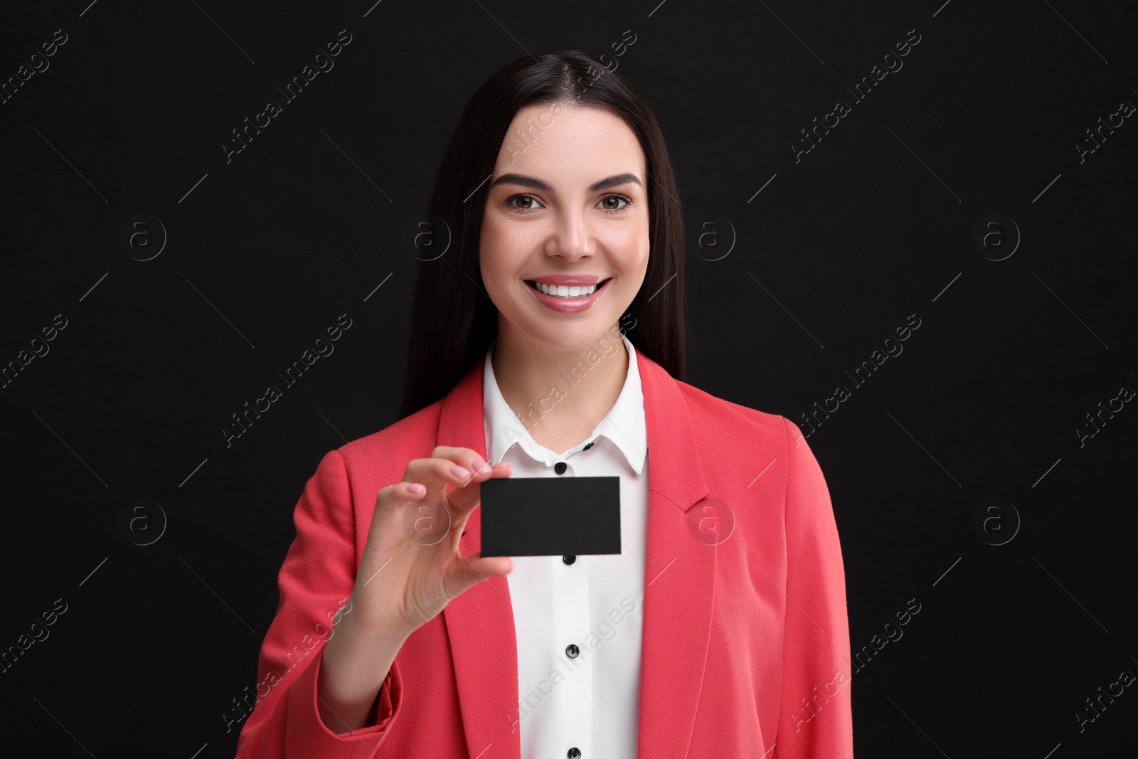 Photo of Happy woman holding blank business card on black background