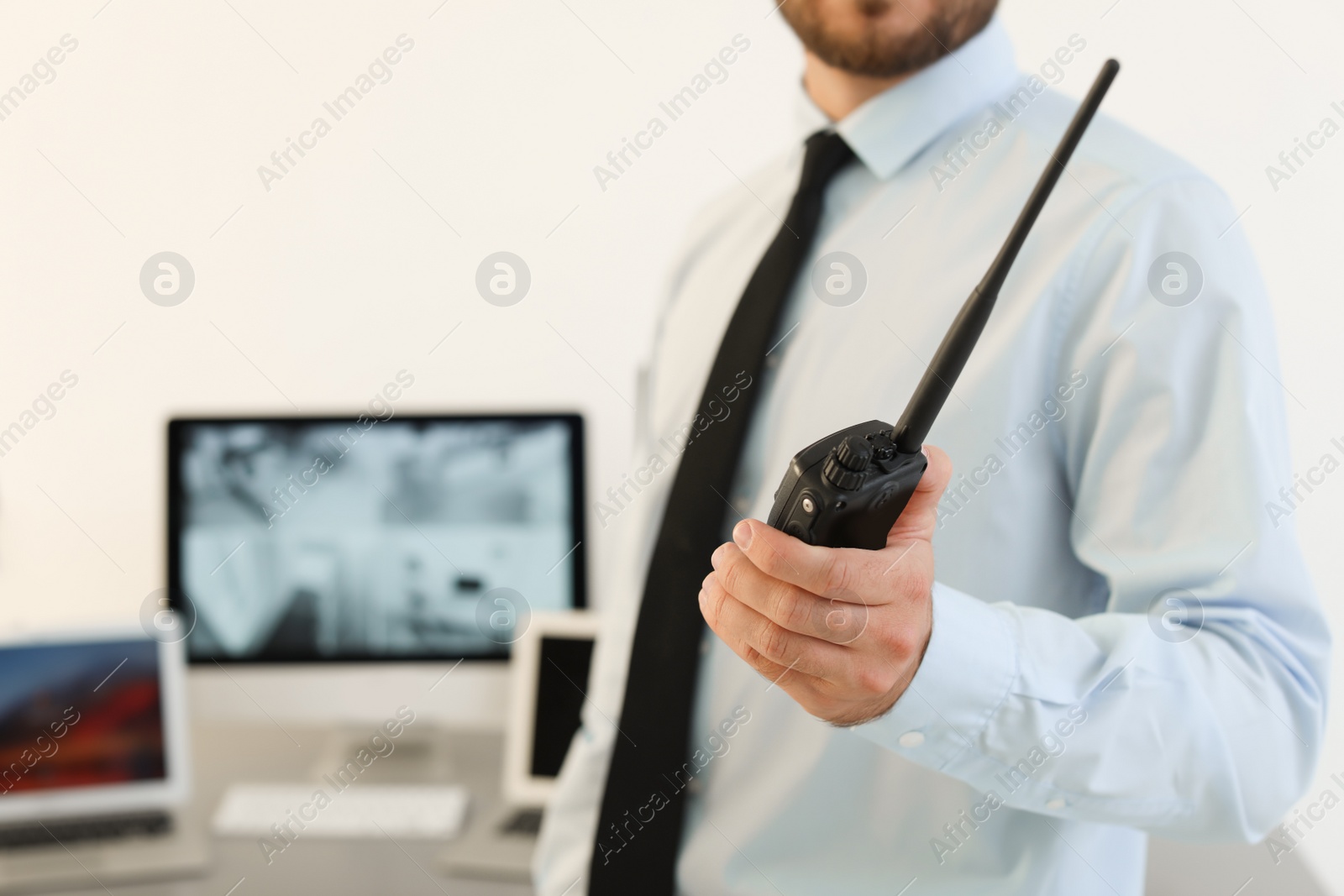 Photo of Male security guard with portable transmitter indoors, closeup