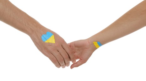 Man and woman with painted Ukrainian flags on their hands against white background, closeup