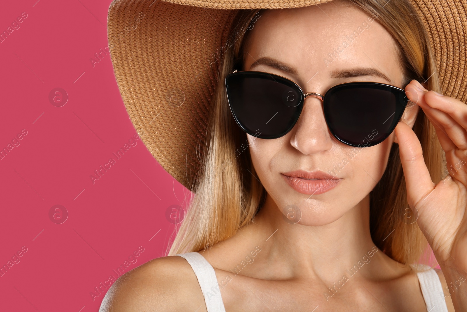 Photo of Beautiful woman in stylish sunglasses on pink background, closeup