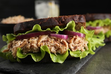 Photo of Delicious sandwich with tuna and vegetables on light grey table, closeup