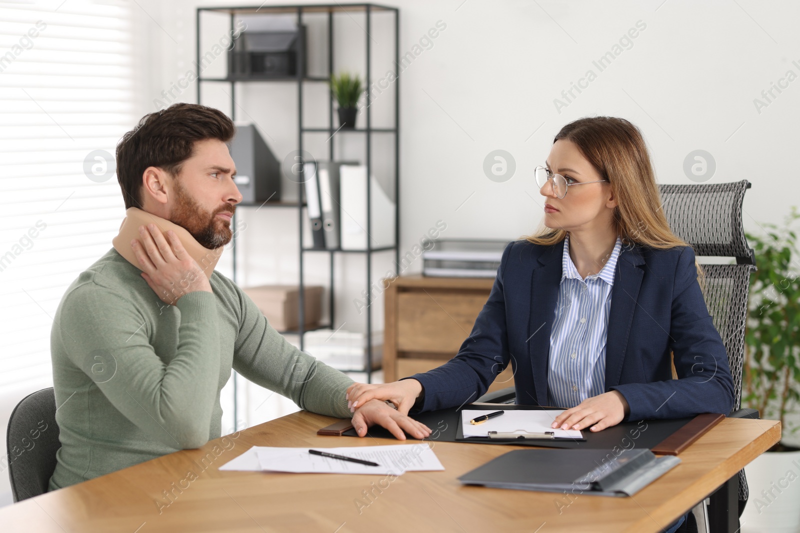 Photo of Injured man having meeting with lawyer in office