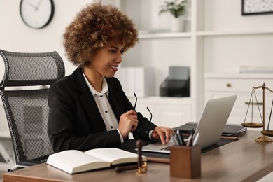 Notary with glasses using laptop at workplace in office