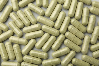 Photo of Vitamin capsules on light grey background, top view. Health supplement