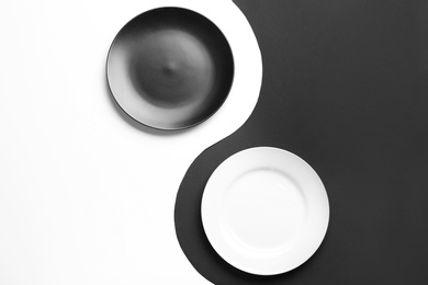 Photo of Yin Yang symbol made with plates on color background, flat lay. Zen concept
