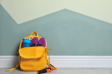 Sports bag with gym equipment on floor indoors