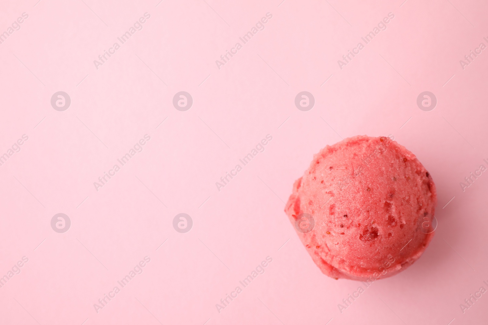 Photo of Scoop of delicious strawberry ice cream on pink background, top view. Space for text