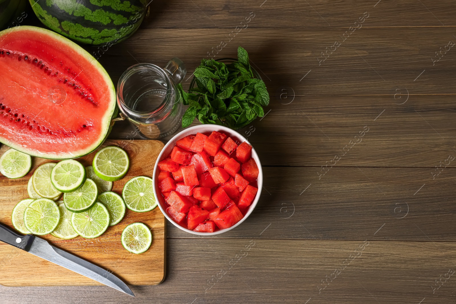 Photo of Fresh ingredients for making watermelon drink with lime on wooden table, above view. Space for text